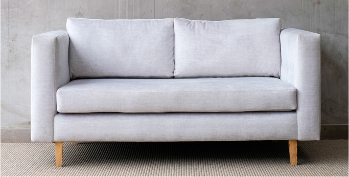 Grey Pure Love Home Couch against a grey wall